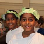 Students smile wearing crowns and robes before the school play