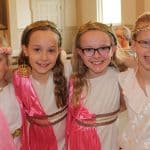 Students smile in their pink ancient greek costumes