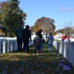 people walk through the rows of American Veteran Gravestones