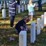 People place American flags in front of veteran tombstones